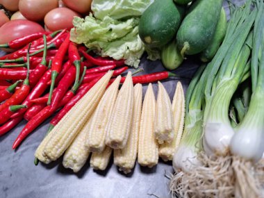 Masadaki taze sebze yığınının fotoğrafı: domates, taze biber, salatalık, marul, taze soğan, bebek mısırı..