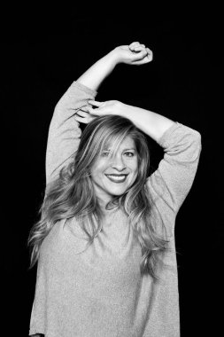 Siyah arka planda mutlu orta yaşlı bir kadının siyah beyaz portresi