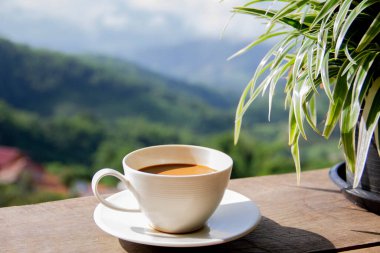 Beyaz kahve fincanı ve dağ manzaralı kahve.