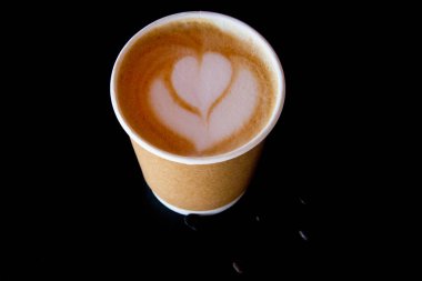 Kağıt kapuçino fincanlarını kaldırır, siyah arka planda sanat kahvesi, üst manzara.