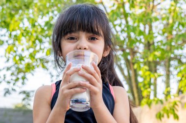 Onun yakın plan portresi. O, evinin önünde oynadıktan sonra bir bardak soğuk süt içer..