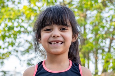 Onun yakın plan portresi. O arkadaş canlısı, çekici, tatlı, meraklı ve neşeli. Spor elbiseli küçük bir kız..