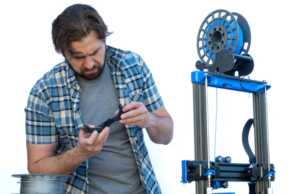 3D baskıdan kaynaklanan desteğe bakan adam.