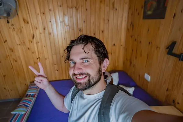 Turist çocuk kiralık bir odada selfie çekiyor. Barış işaretini elleriyle yapıyor..