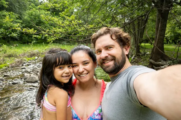 Latin family on vacation takes a selfie.