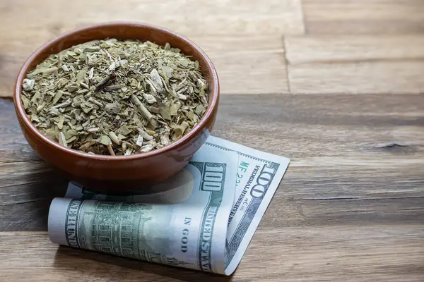 Concept of the cost of yerba mate with a hundred dollar bill