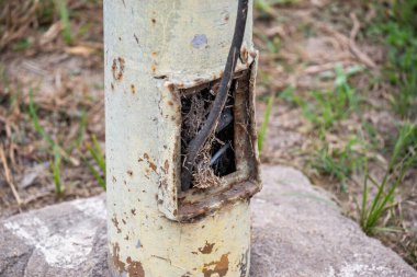 Kabloları açık ve kötü durumda olan bir elektrik direği. Kamu elektrik tesisatı kötü durumda.