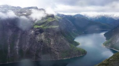 Bulutlu bir günde Norveç fiyort ve dağları üzerinde hava manzarası. Yüksek kalite 4k drone görüntüsü.