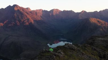 İskoçya 'nın Skye Adası' ndaki Jagged Dağları, Göller ve Deniz 'in Renkli Gökyüzü ile Gün Doğumu manzarası. Cuillin Dağları 'nda yürüyüş ve kamp. - Evet. Yüksek kalite 4k drone videosu.