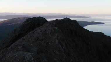 İskoçya 'nın Skye Adası' ndaki Jagged Dağları, Göller ve Deniz 'in Renkli Gökyüzü ile Gün Doğumu manzarası. Cuillin Dağları 'nda yürüyüş ve kamp. - Evet. Yüksek kalite 4k drone videosu.