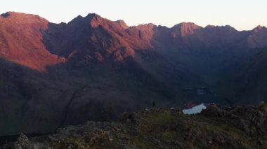 İskoçya 'nın Skye Adası' ndaki Jagged Dağları, Göller ve Deniz 'in Renkli Gökyüzü ile Gün Doğumu manzarası. Cuillin Dağları 'nda yürüyüş ve kamp. - Evet. Yüksek kalite 4k drone videosu.