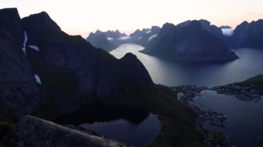 Kuzey Norveç 'teki Lofoten Adaları' nın dramatik dağları ve fiyortları üzerinde güzel bir gün batımı - Kuzey Kutup Dairesi 'nde gece yarısı güneşi. Yüksek kalite 4k görüntü