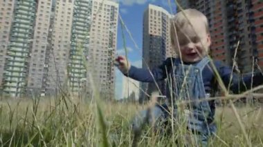 Yüksek Konut Binalarının Arkaplanına Karşı Bir Çocuk Oynuyor