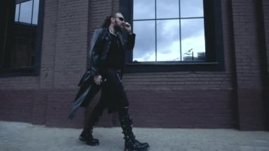 Siyah deri ceketli adam duvarda yürüyor, Gotik tarzında.