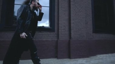 Siyah deri ceketli adam duvarda yürüyor, Gotik tarzında.