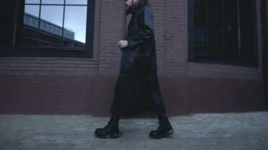 Siyah deri ceketli adam duvarda yürüyor, Gotik tarzında.