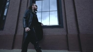 Siyah deri ceketli adam duvarda yürüyor, Gotik tarzında.