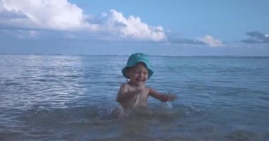 Panama Şapkalı Çocuk Okyanusta Suda Oynuyor