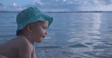Panama Şapkalı Çocuk Okyanusta Suda Oynuyor