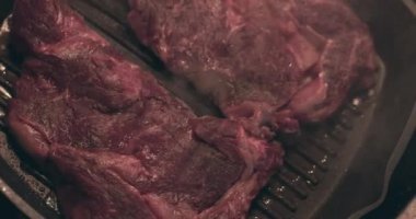 Izgarada kızartılmış dumanlı büyük et bifteği.