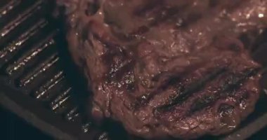 Izgarada kızartılmış dumanlı büyük et bifteği.