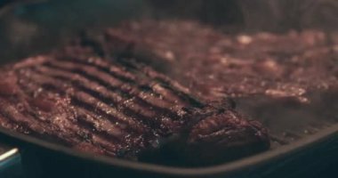 Izgarada kızartılmış dumanlı büyük et bifteği.