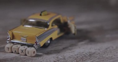 Küplerden yapılmış yazıt taksisi olan küçük sarı bir araba.