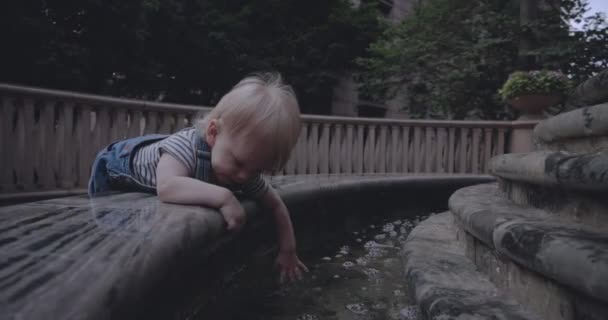 Bambino Sulla Fontana Tocca Acqua Con Mano — Video Stock