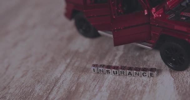 赤い車の近くのキューブ上の碑文保険 ミニチュア — ストック動画