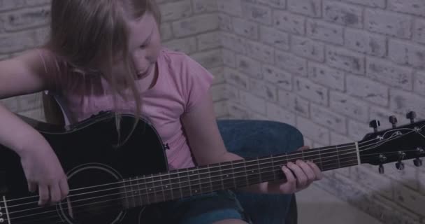 Gadis Remaja Terang Belajar Untuk Memainkan Gitar Hitam — Stok Video