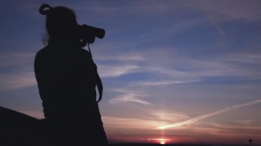 Sunset 'teki Kız Dürbünle yola bakıyor