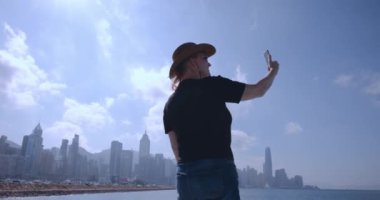 Şapkalı Kız, Hong Kong 'da bir panorama üzerine video bağlantısı kuruyor.