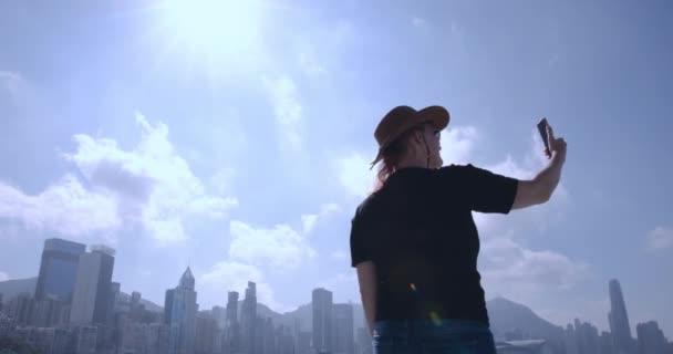 Dziewczyna Kapeluszu Komunikuje Się Przez Łącze Wideo Panoramie Miasta Hong — Wideo stockowe