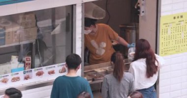 Hong Kong 'daki sokak kafelerinde insanlar kuyrukta bekliyor. Asya sokak yemekleri.