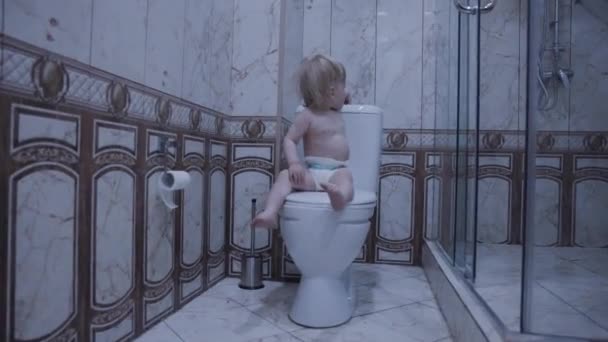 Bebé Está Sentado Inodoro Con Papel Higiénico — Vídeo de stock