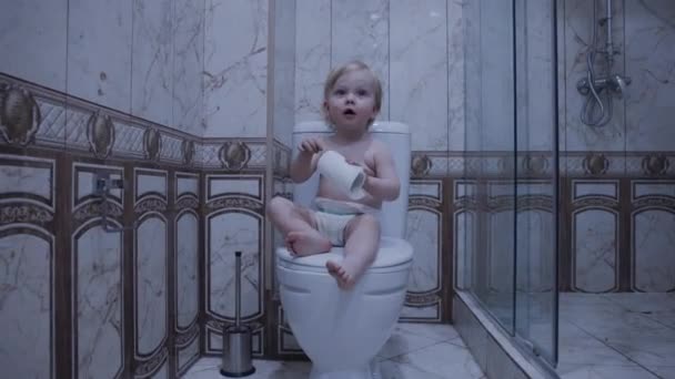 Baby Zit Het Toilet Met Toiletpapier — Stockvideo