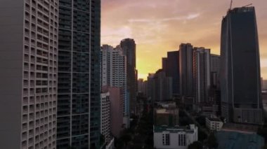 Manila 'nın gökdelenleri üzerinde uçmak Gün batımında, Filipinler, hava manzarası