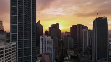 Manila 'nın gökdelenleri üzerinde uçmak Gün batımında, Filipinler, hava manzarası