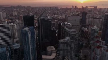 Manila 'nın gökdelenleri üzerinde uçmak Gün batımında, Filipinler, hava manzarası