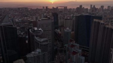 Manila 'nın gökdelenleri üzerinde uçmak Gün batımında, Filipinler, hava manzarası
