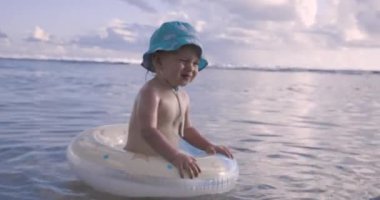 Bebek okyanusta şişme bir dairede yüzüyor.