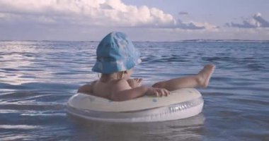 Bebek okyanusta şişme bir dairede yüzüyor.