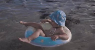 Bebek okyanusta şişme bir dairede yüzüyor.