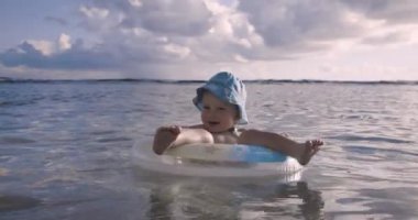 Bebek okyanusta şişme bir dairede yüzüyor.