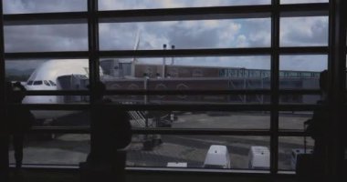 İnsanlar bir uçağa biniyor, havaalanı terminali.