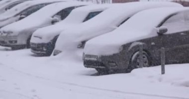 Kış tipi ve park yerinde karla kaplı arabalar.