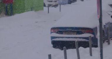 Kış tipi ve park yerinde karla kaplı arabalar.