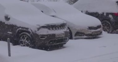 Kış tipi ve park yerinde karla kaplı arabalar.