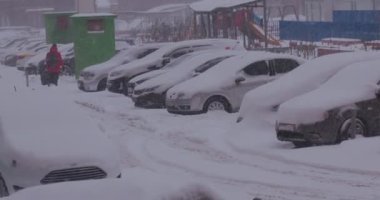 Kış tipi ve park yerinde karla kaplı arabalar.