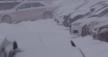 Kış tipi ve park yerinde karla kaplı arabalar.